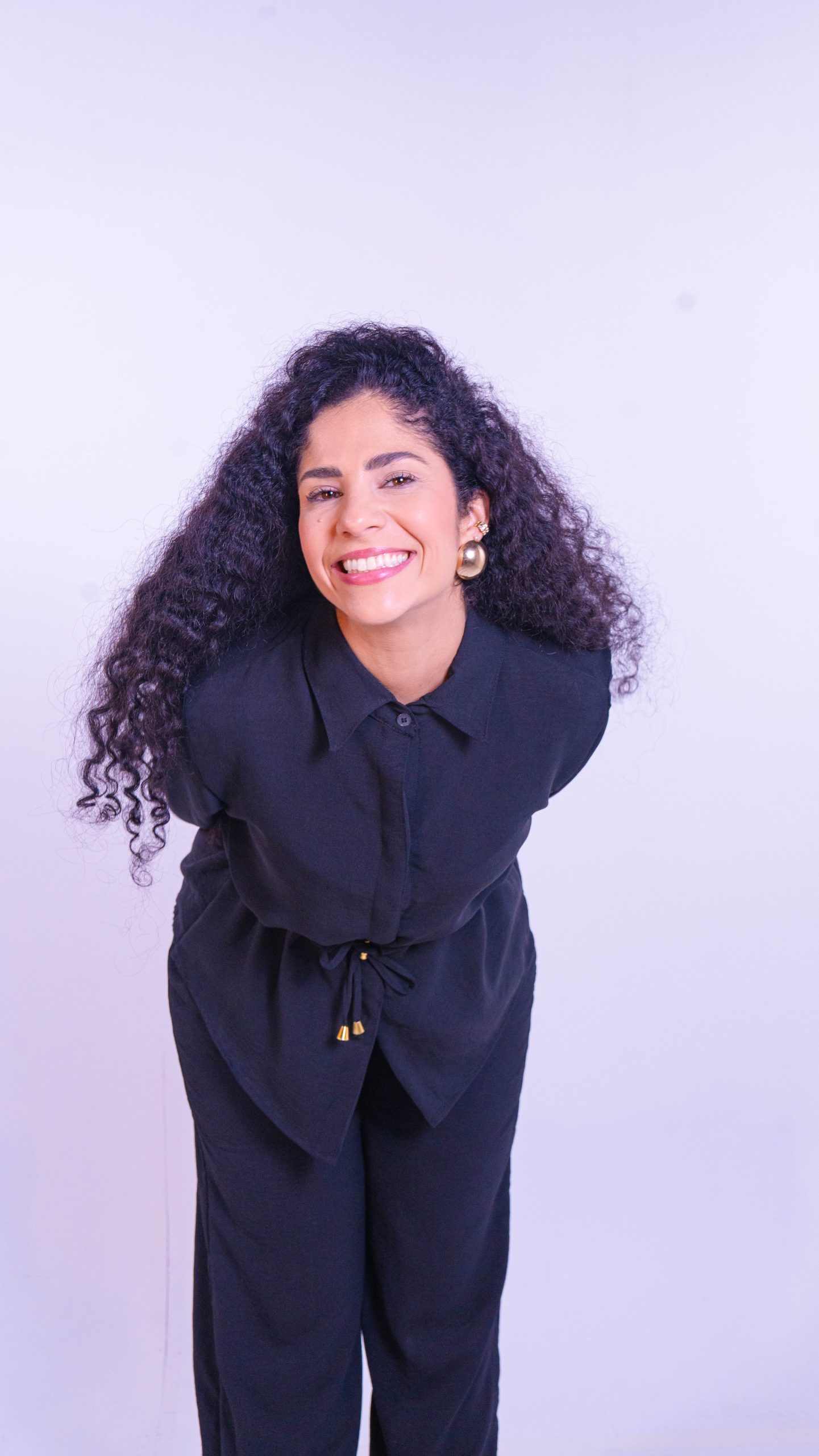 Dra. Sara Dutra em pé, sorrindo com os cabelos soltos